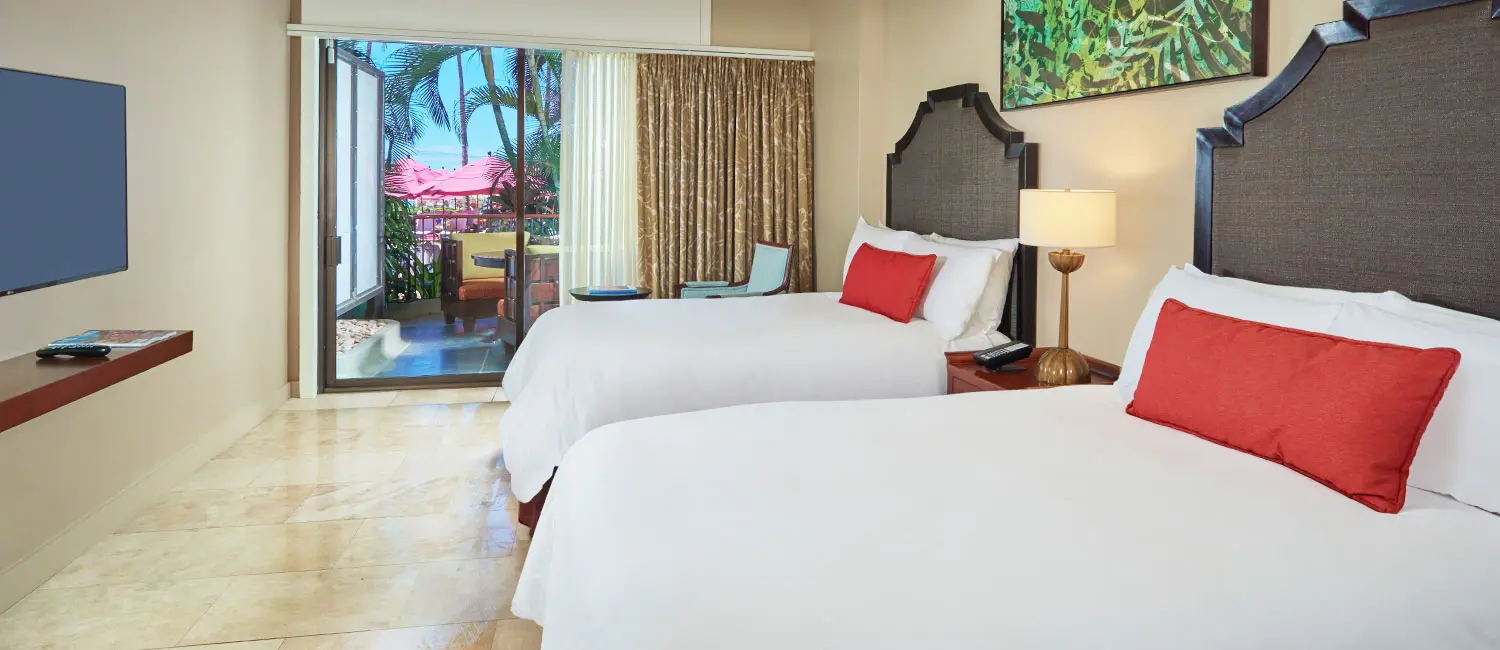 Family Loft Suite balcony overlooking the poolside with lush greenery and sparkling water below.