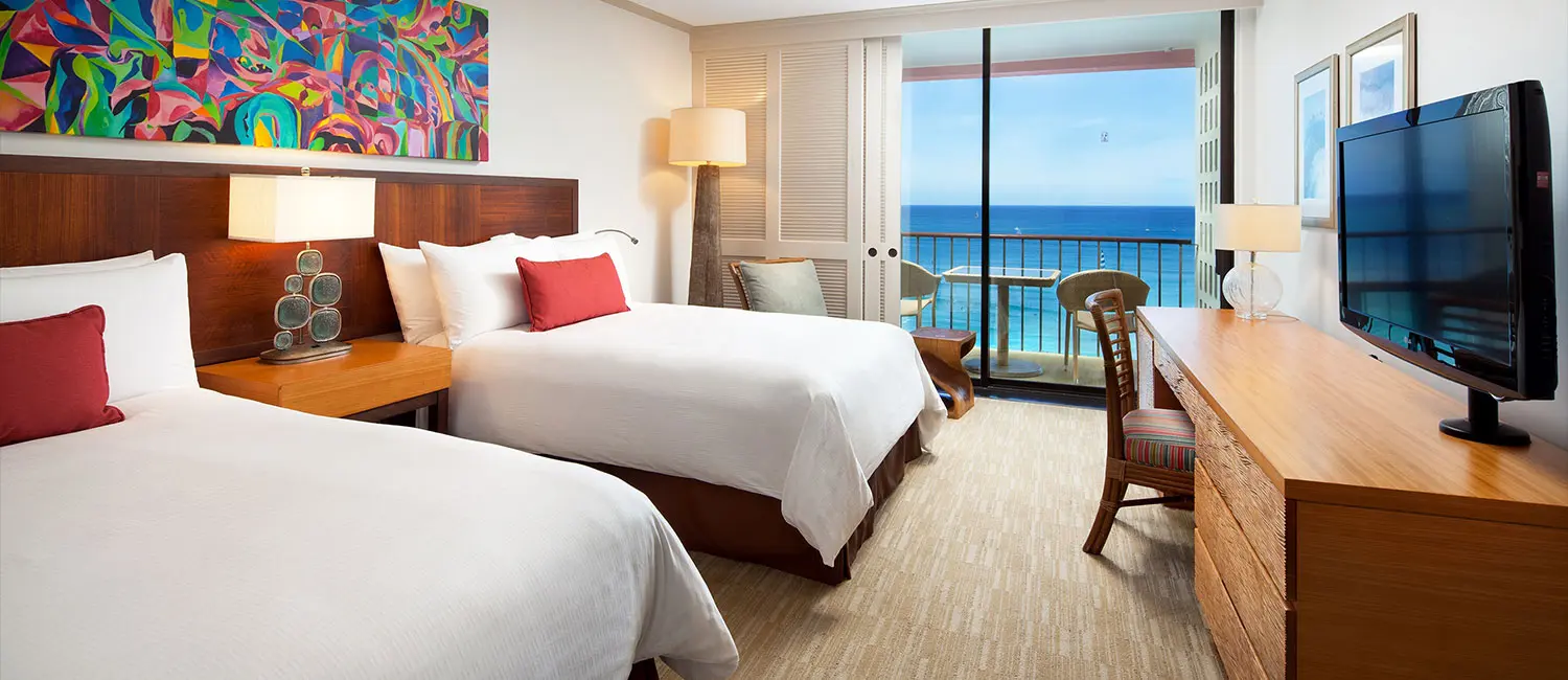 Ocean-view twin room with modern wood furniture and colorful artwork.