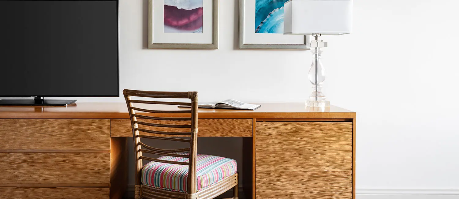 Wooden desk and framed art create a calm workspace atmosphere.