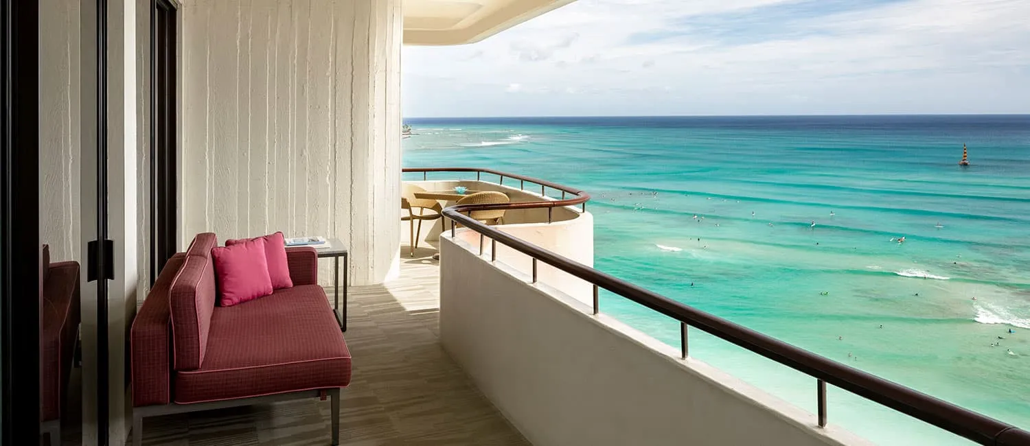 Ocean view from the Ali‘i Suite balcony with a pink sofa.