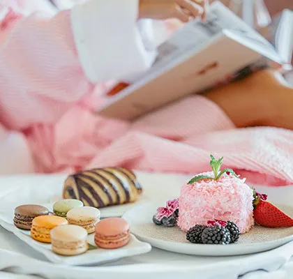 Photo of a woman relaxing on the bed with sweets